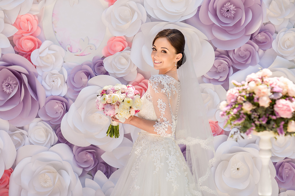 Bride In Front Of A Wall Of Paper Flowers