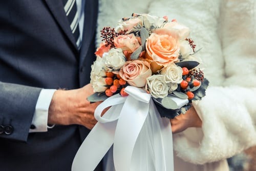 bouquet of flowers being held by a couple for a winter wedding